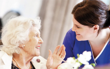 resident and carer looking at each other smiling