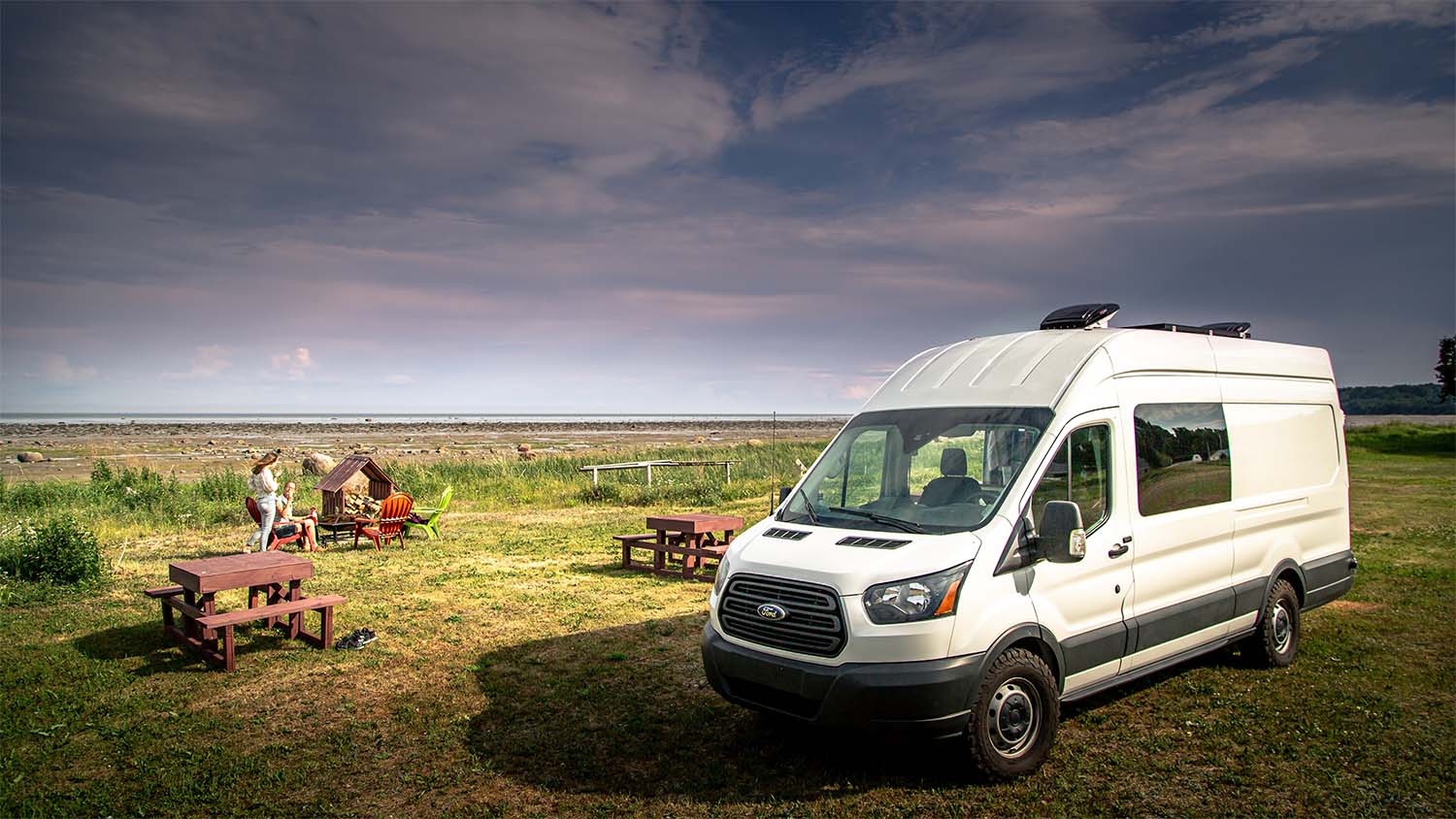 minibus parked in a field with benches behind
