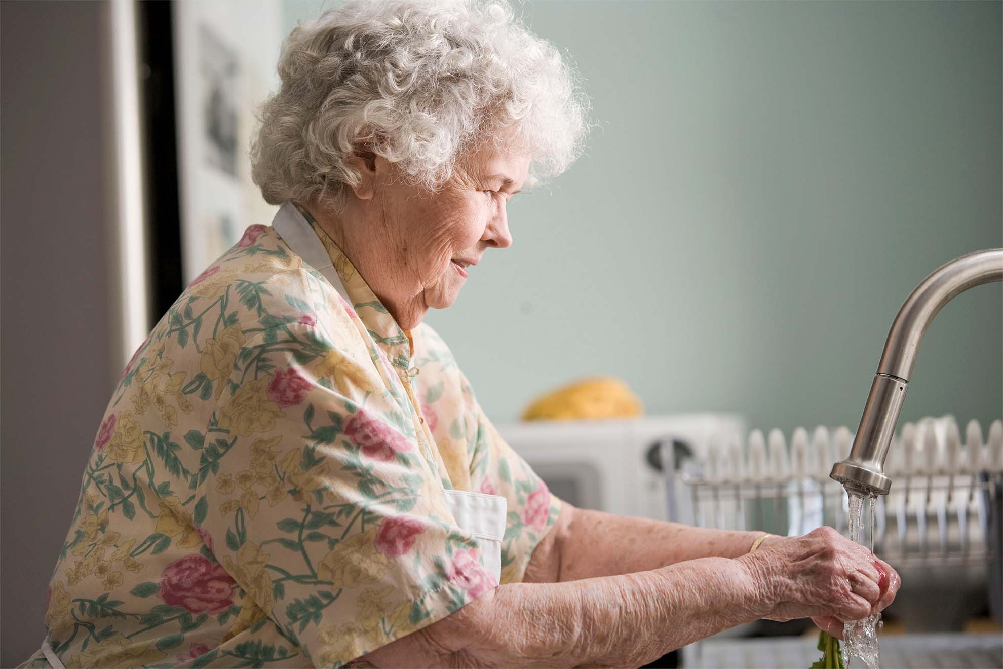 elderly woman doing the washing up