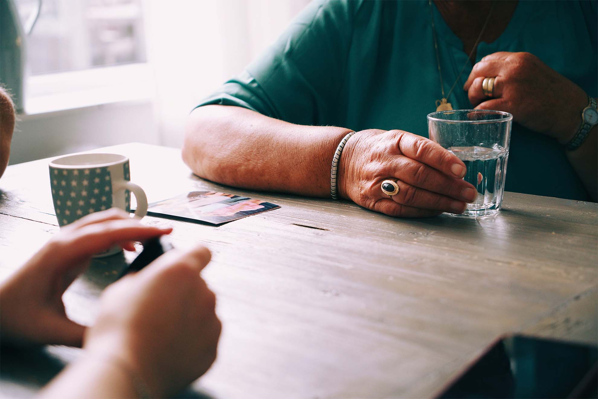 2 residents sat down playing cards together with a drink