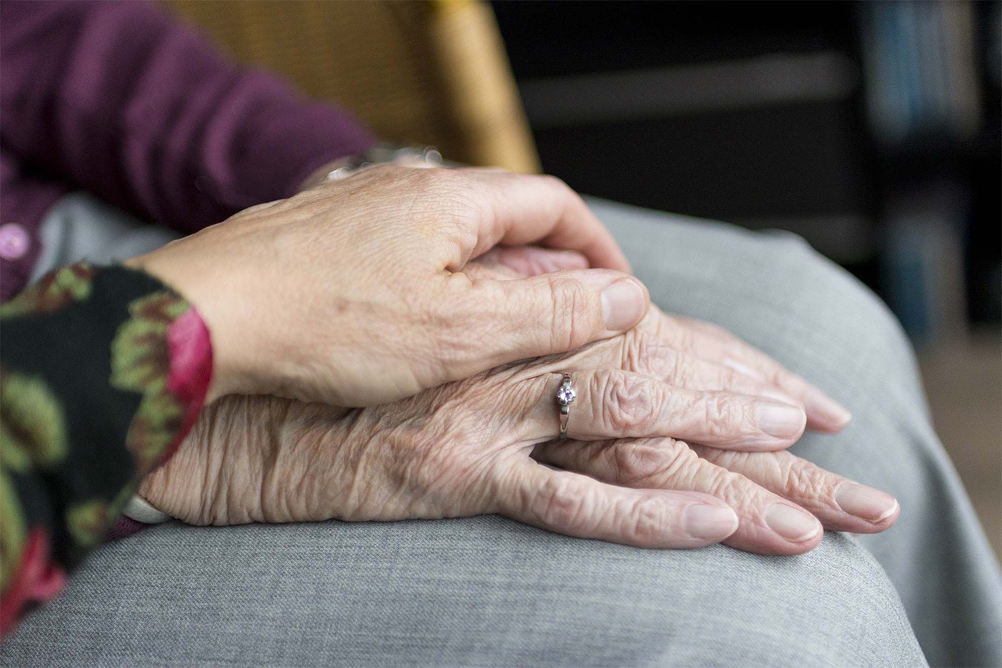 elderly people with their hands on top of each other in support