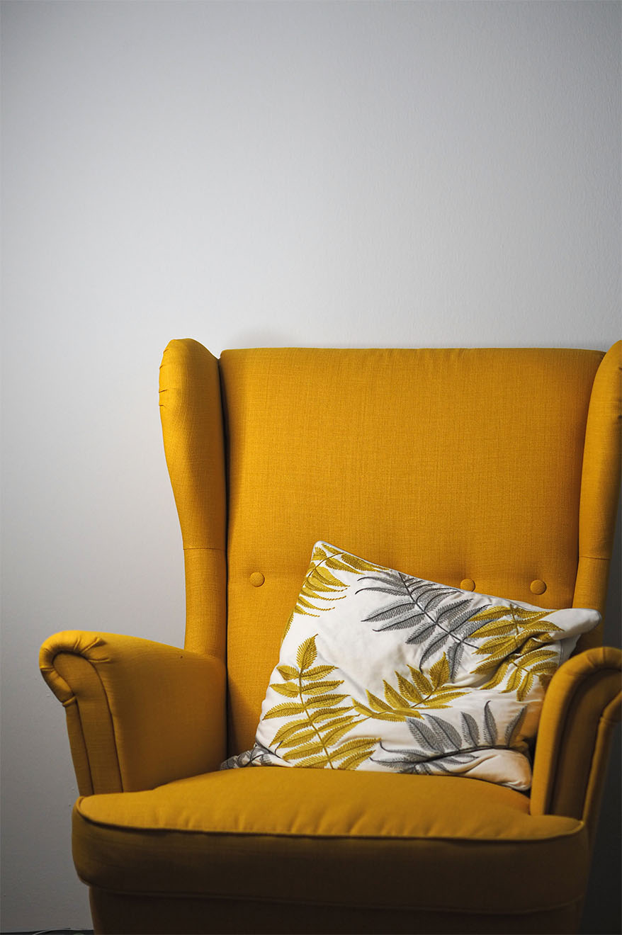 yellow armchair with cushion on it