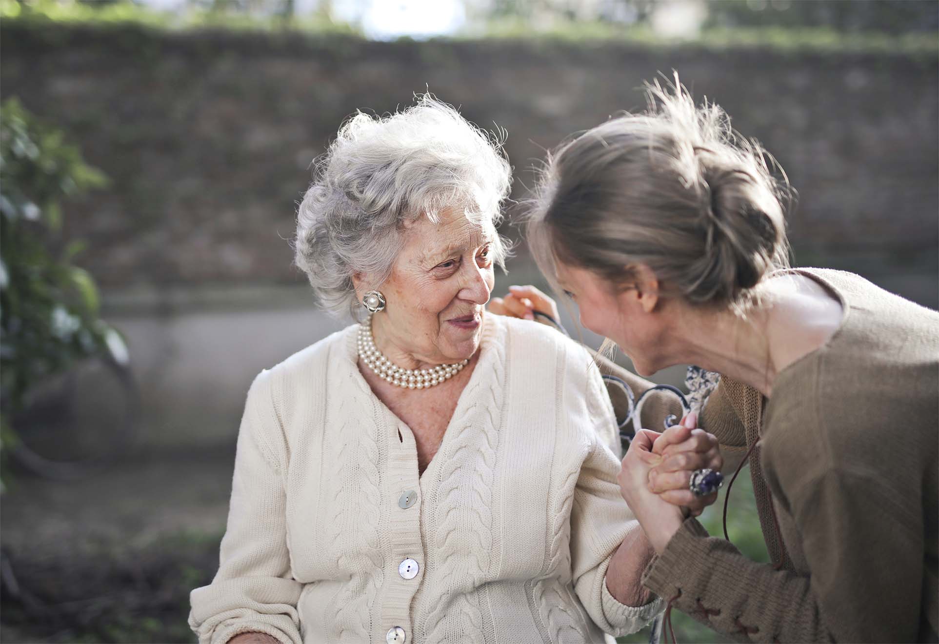 resident and loved one looking at each other and smiling in a park